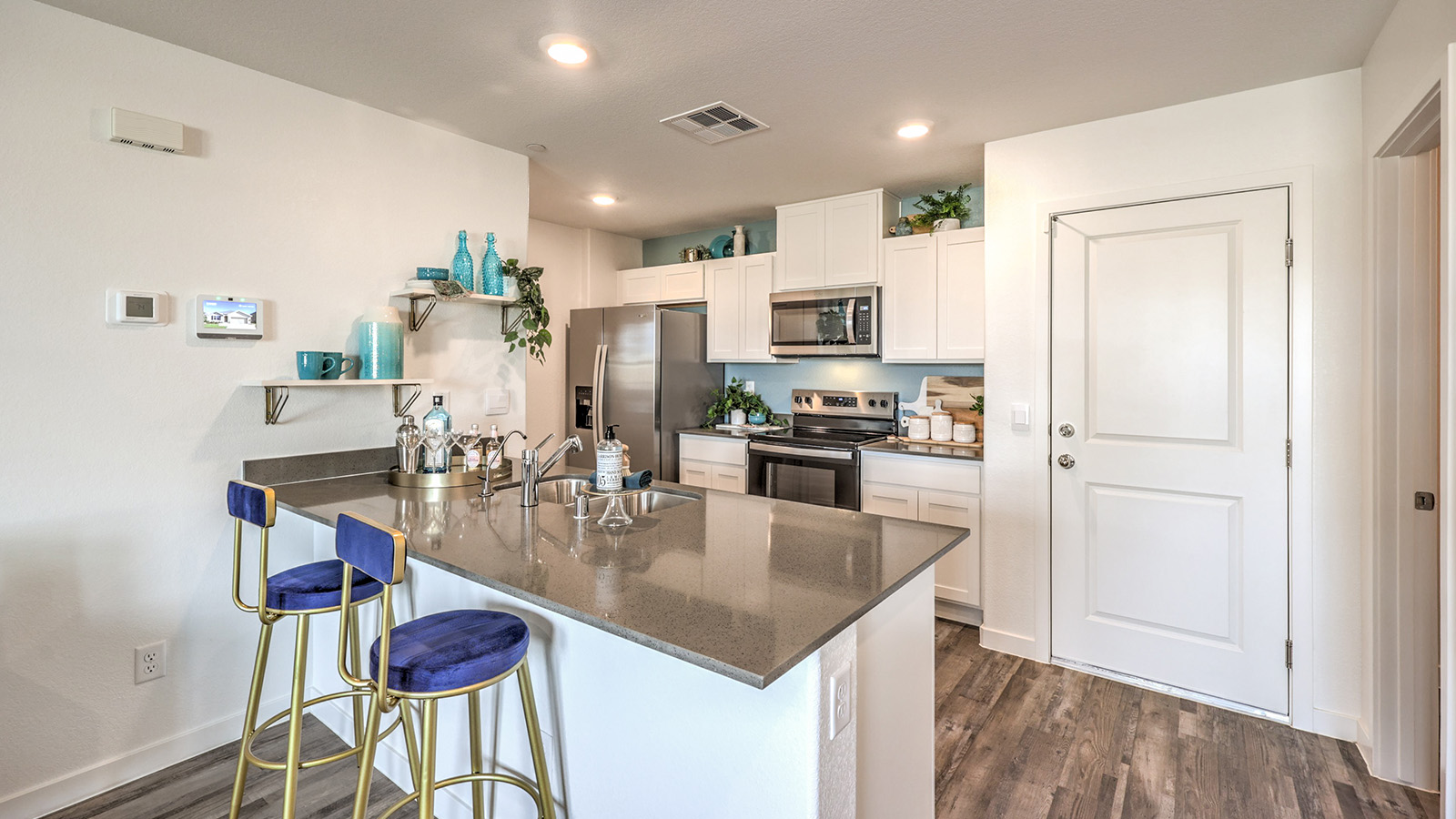 Our 1309 model kitchen in the Symmetry Trails Community with white shaker style style cabinets, quartz countertops, and Whirlpool Stainless Steel appliances.