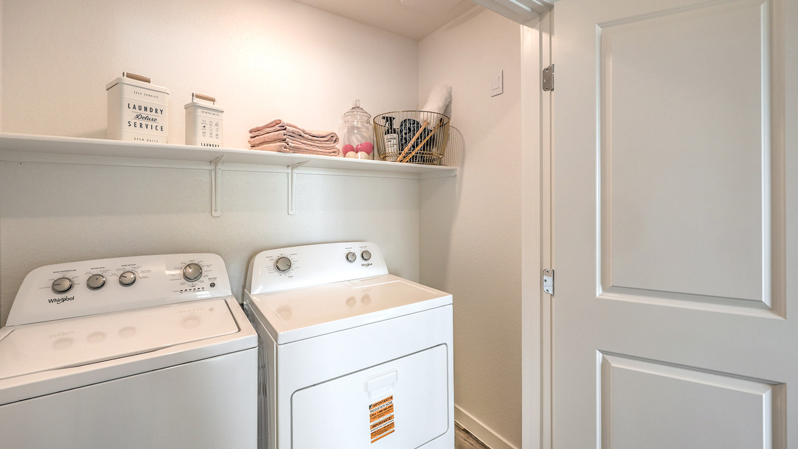 Our Symmetry Trails 1309 model laundry room with a shelf and washer and dryer.
