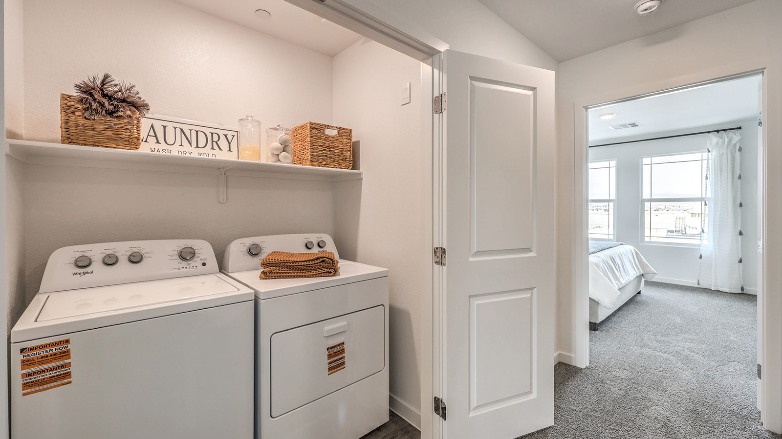 Our Symmetry Trails 1410 model laundry room with a shelf and washer and dryer.