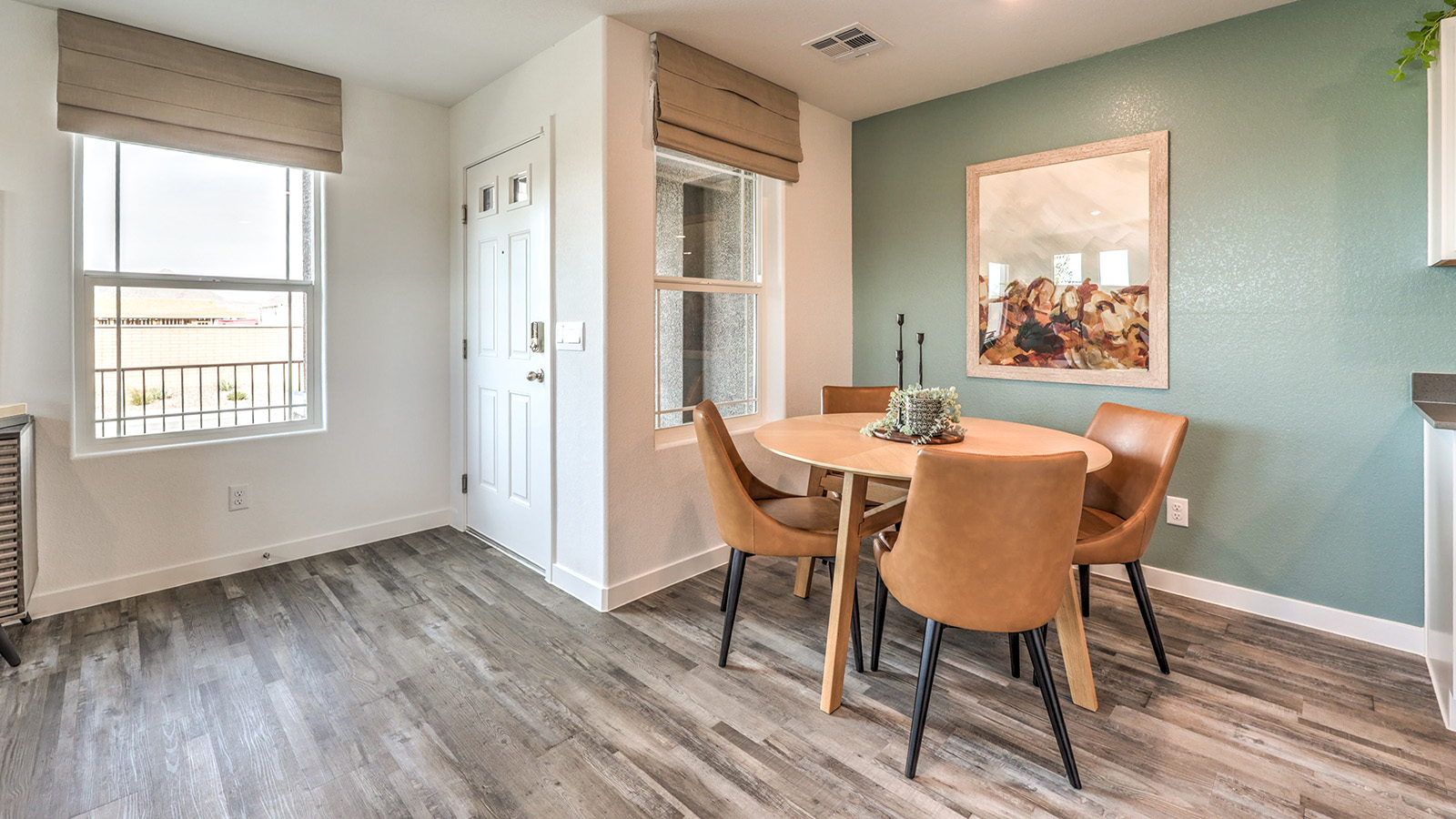The Symmetry Trails 1410 model Dining Room adjacent to the kitchen with a table and window.