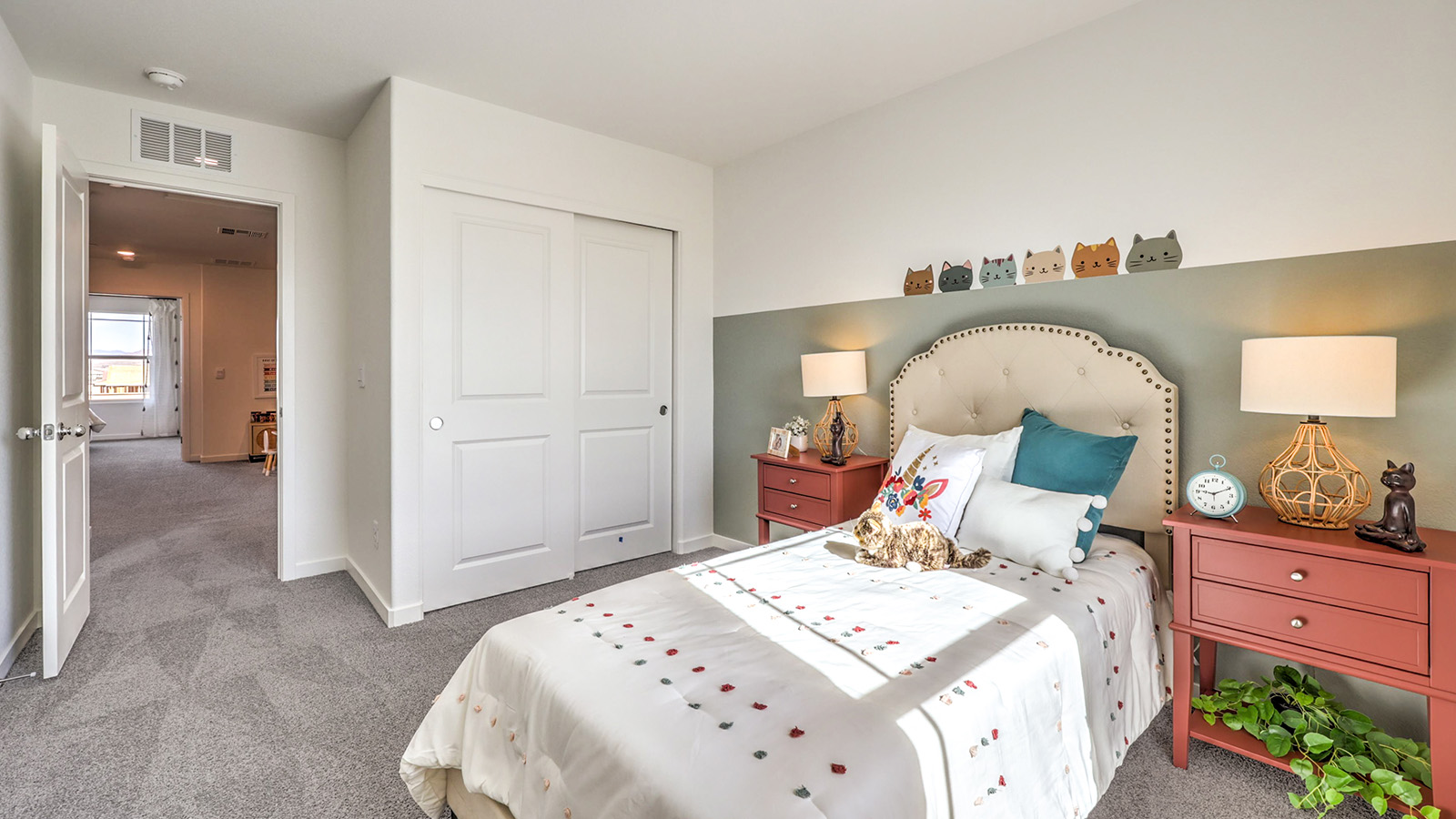 Bedroom Three in our Symmetry Trails 1410 model with carpet flooring, an accent wall, sliding closet, and one window.