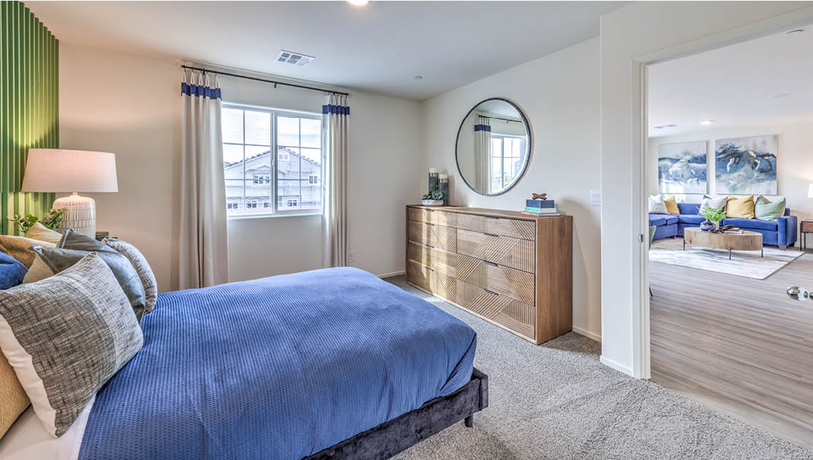 The Bedroom One Suite in our Juno Pointe 1171 model with carpet flooring, a large window, and recessed ceiling lights.
