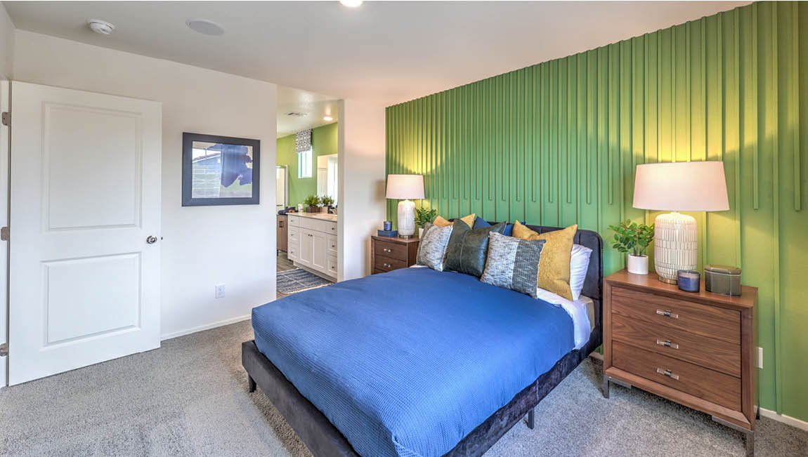 The Bedroom One Suite in our Juno Pointe 1171 model with carpet flooring, a large window, and recessed ceiling lights.