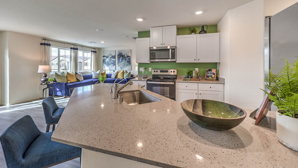 Our 1171 model kitchen in the Juno Pointe Community with white shaker style cabinets, quartz countertops, a Moen Pull Out Kitchen Faucet at the sink, and Whirlpool Stainless Steel appliances.
