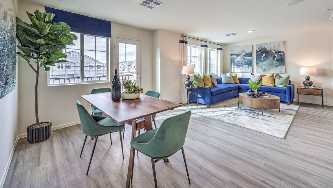 The Juno Pointe 1171 model Dining Room adjacent to the kitchen and great room with a table, large window, and door to the balcony.