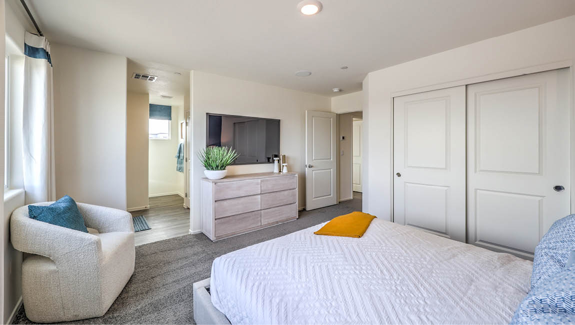 The Bedroom One Suite in our Juno Pointe 1349 model with carpet flooring, large windows, and recessed ceiling lights.