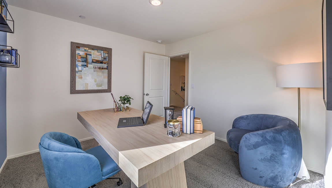 The Office/Bedroom Two option in our Juno Pointe 1349 model with carpet flooring, a sliding closet, and a window, furnished with a desk and chair.