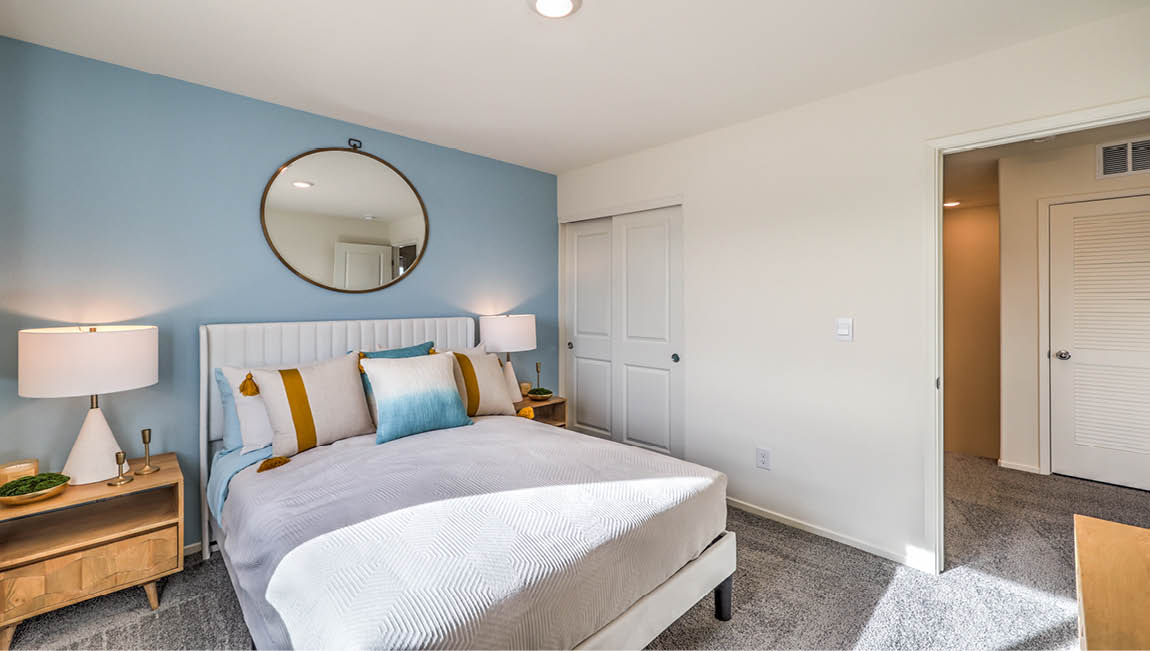 Bedroom Three in our Juno Pointe 1349 model with carpet flooring, a sliding closet, and a window.