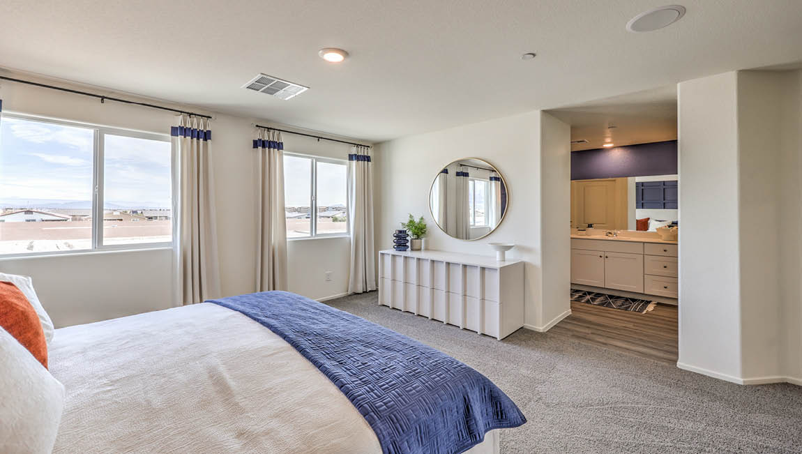 The Bedroom One Suite in our Juno Pointe 1600 model with carpet flooring, large windows, and recessed ceiling lights.
