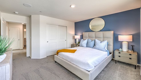 The Bedroom One Suite in our Juno Pointe 1349 model with carpet flooring, large windows, and recessed ceiling lights.