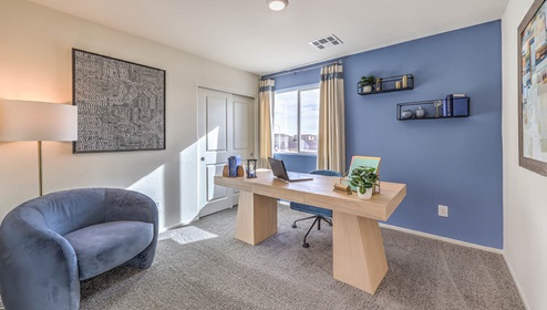 The Office/Bedroom Two option in our Juno Pointe 1349 model with carpet flooring, a sliding closet, and a window, furnished with a desk and chair.