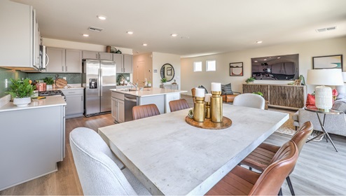 The Heartland Bay 1865 model Dining Room adjacent to the kitchen with a table and window.