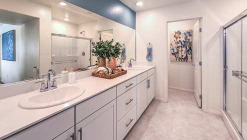 Attached to the Bedroom One Suite, our 2988 model bathroom with granite countertops at the double Bath Vanity, a walk-in shower, walk-in closet, linen closet, mirror, and white cabinets.