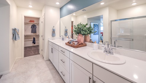 Attached to the Bedroom One Suite, our 2988 model bathroom with granite countertops at the double Bath Vanity, a walk-in shower, walk-in closet, linen closet, mirror, and white cabinets.
