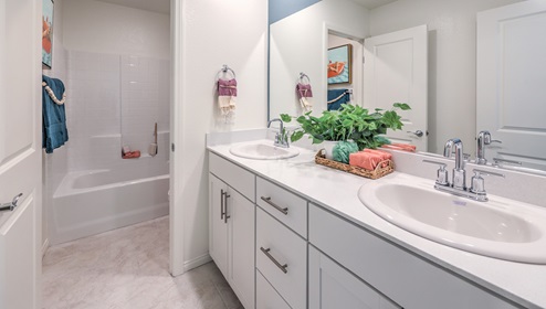 Bathroom Two in our Heartland Falls 3000 model with Granite countertops at the Bath Vanity, a walk-in shower, mirror, and white cabinets.