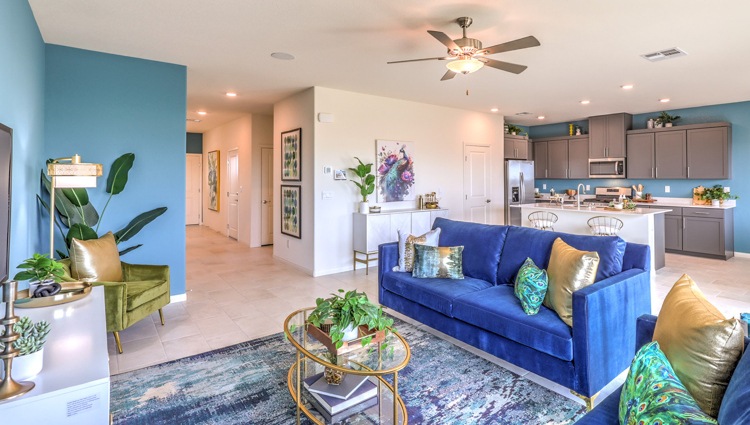 The Heartland Falls 2660 Plan open concept Great Room with ceramic tile flooring, large windows, and a sliding door to the backyard.