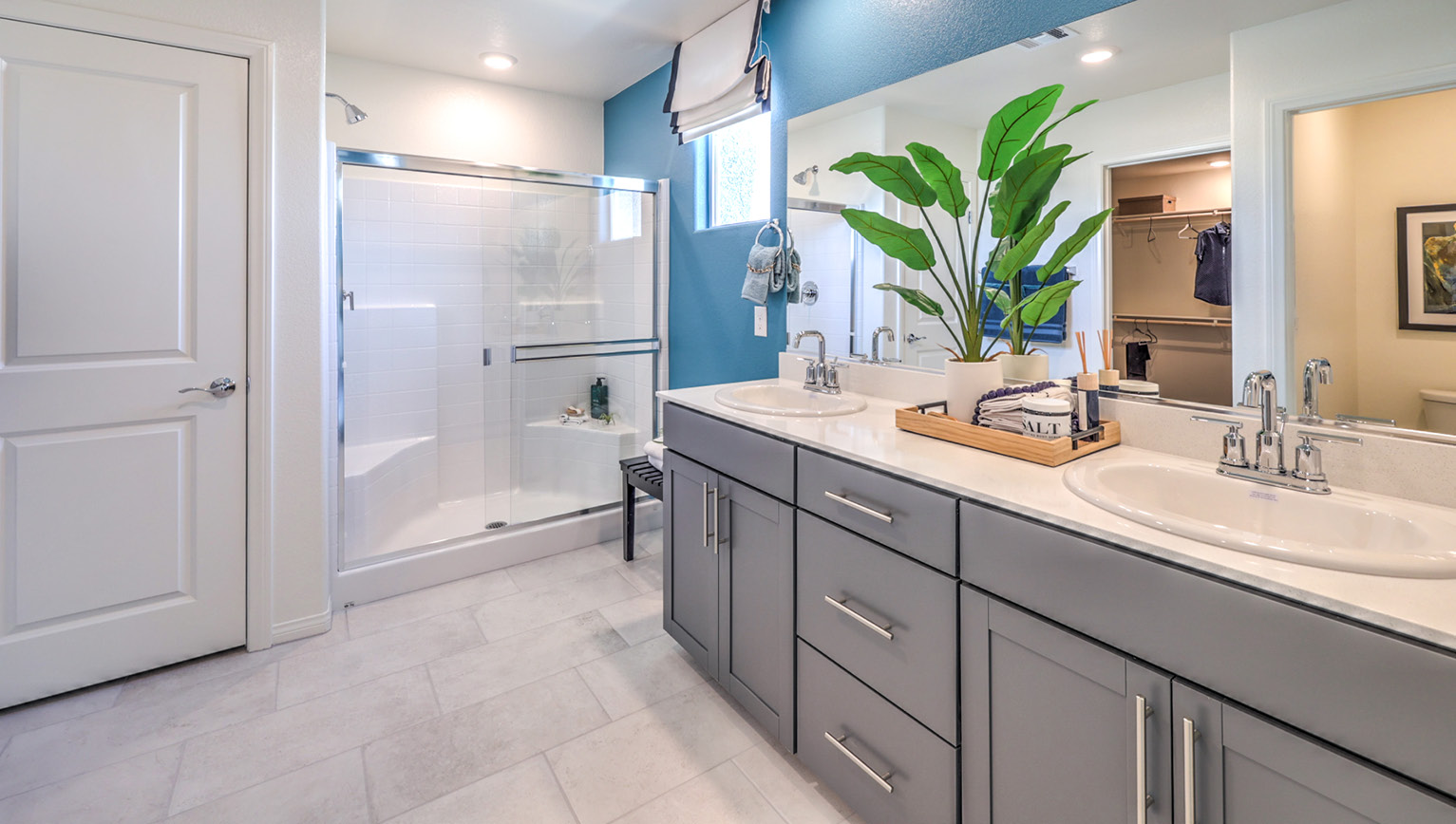 The Bedroom One Suite in our Heartland Falls 2660 model with carpet flooring, ceiling fan with a light kit, and large windows.