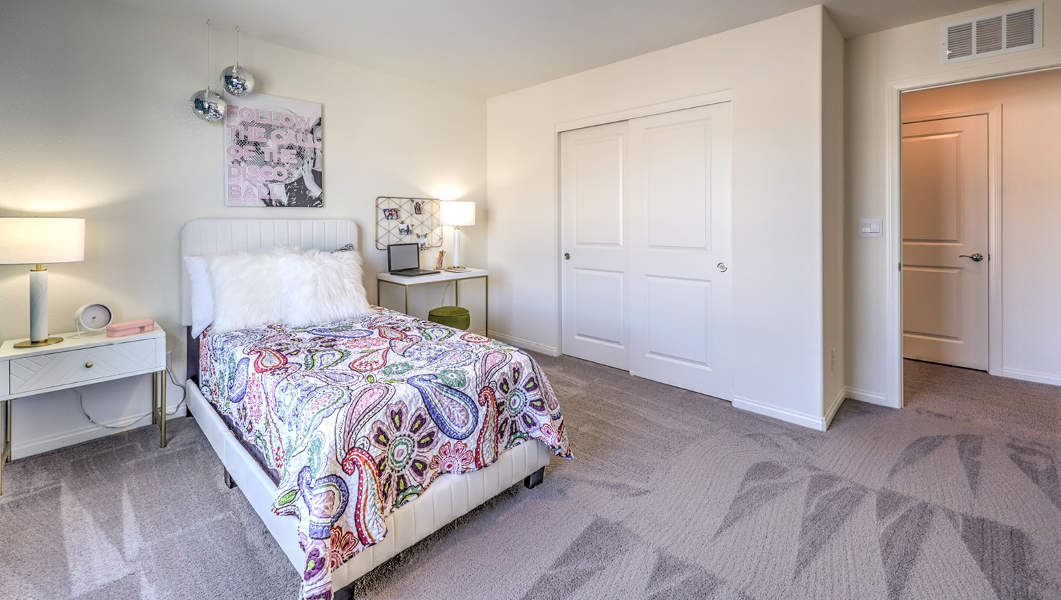 Bedroom Two in our Heartland Falls 2660 model with carpet flooring, a sliding closet, and a window.