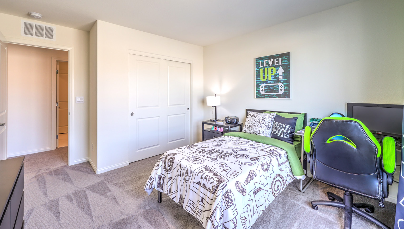 Bedroom Three in our Heartland Falls 2660 model with carpet flooring, a sliding closet, and a window.