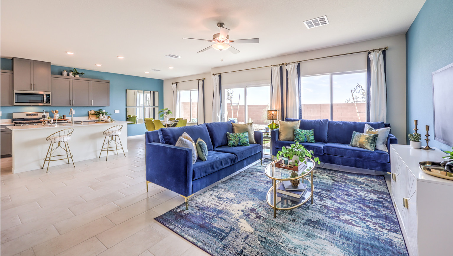 The Heartland Falls 2660 Plan open concept Great Room with ceramic tile flooring, large windows, and a sliding door to the backyard.