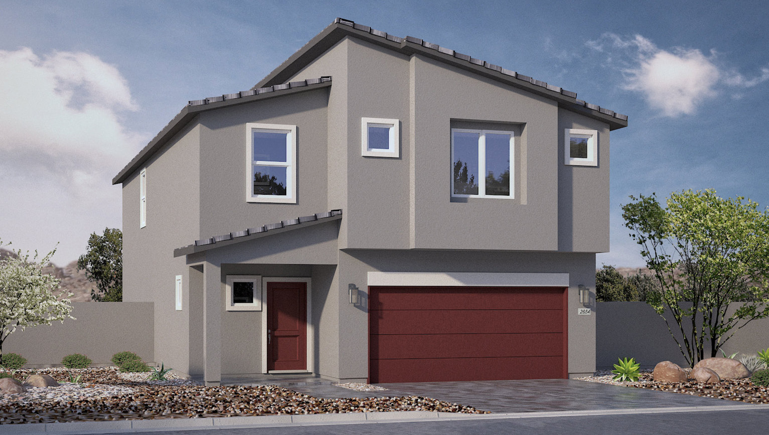 Our 2660 model home in the Heartland Falls community with grey and red exterior paint schemes, a flat tile roof, front yard landscaping, and paver walkways.