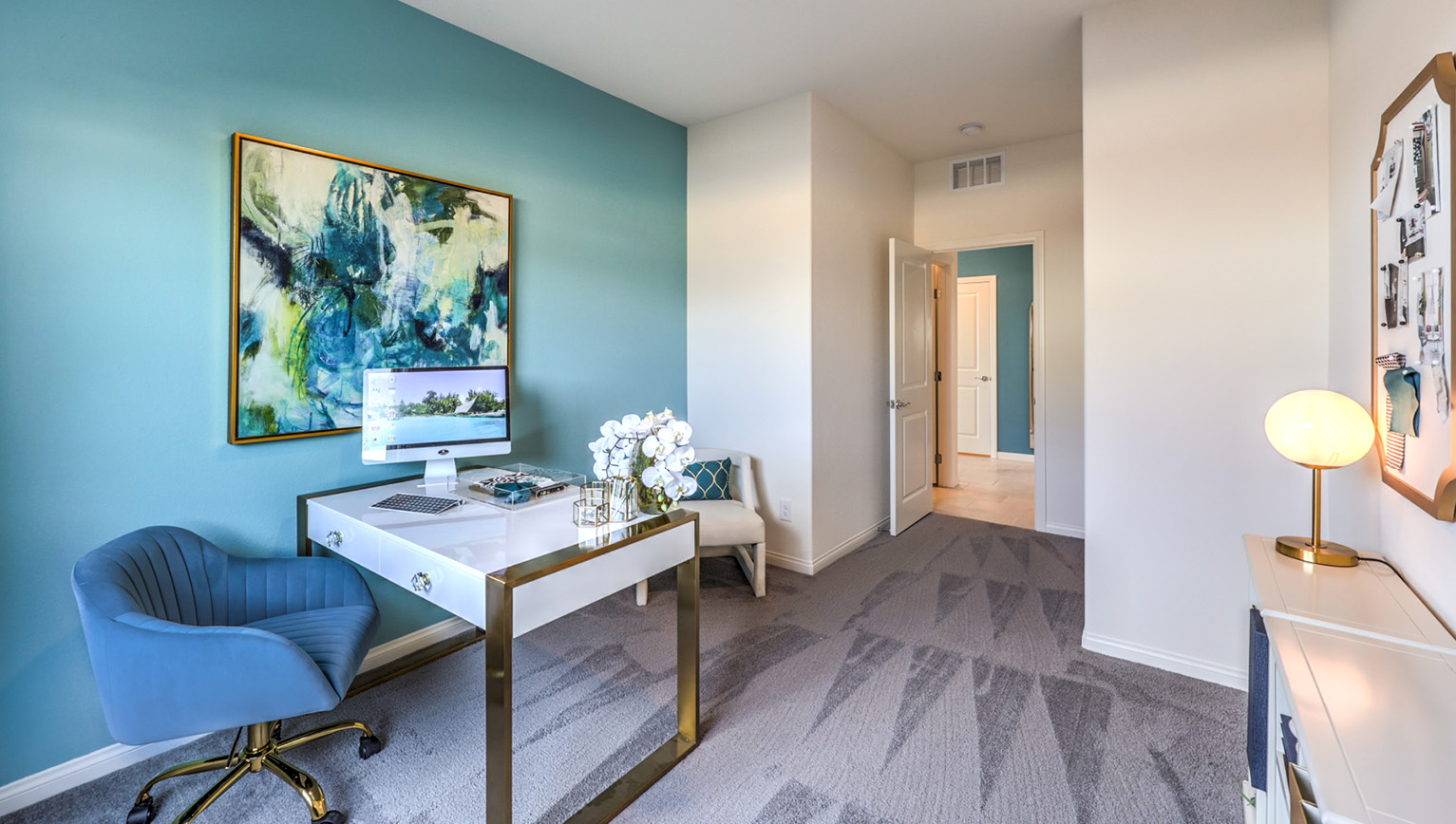 The Office/Bedroom Five option in our Heartland Falls 2600 model with carpet flooring and a sliding closet, furnished with a desk and chair.