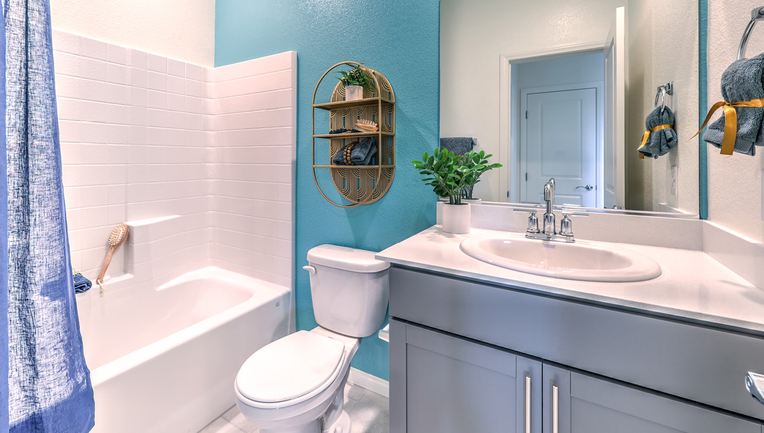 Bathroom Three in our Heartland Falls 2600 model with Granite countertops at the double Bath Vanity, a shower, mirror, and white cabinets.