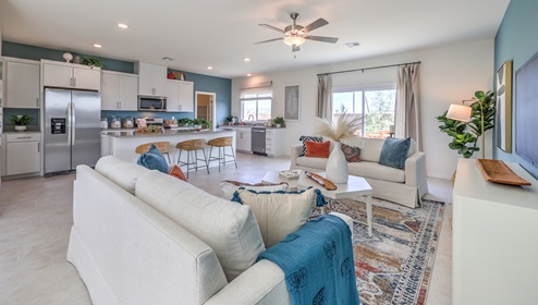 The Heartland Falls 3000 Plan open concept Great Room with ceramic tile flooring, large windows, and a sliding door to the backyard.