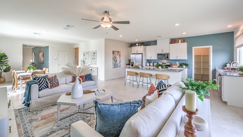 The Heartland Falls 3000 Plan open concept Great Room with ceramic tile flooring, large windows, and a sliding door to the backyard.
