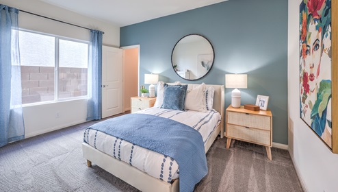 Bedroom Five in our Heartland Falls 3000 model with carpet flooring, a walk in closet, and a window.