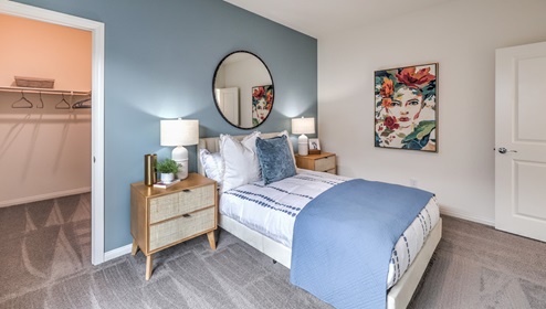 Bedroom Five in our Heartland Falls 3000 model with carpet flooring, a walk in closet, and a window.