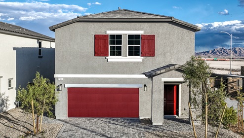 Our 2988 model home in the Heartland Falls community with tan and red exterior paint schemes, a flat tile roof, front yard landscaping, 2-car garage, and paver walkways.