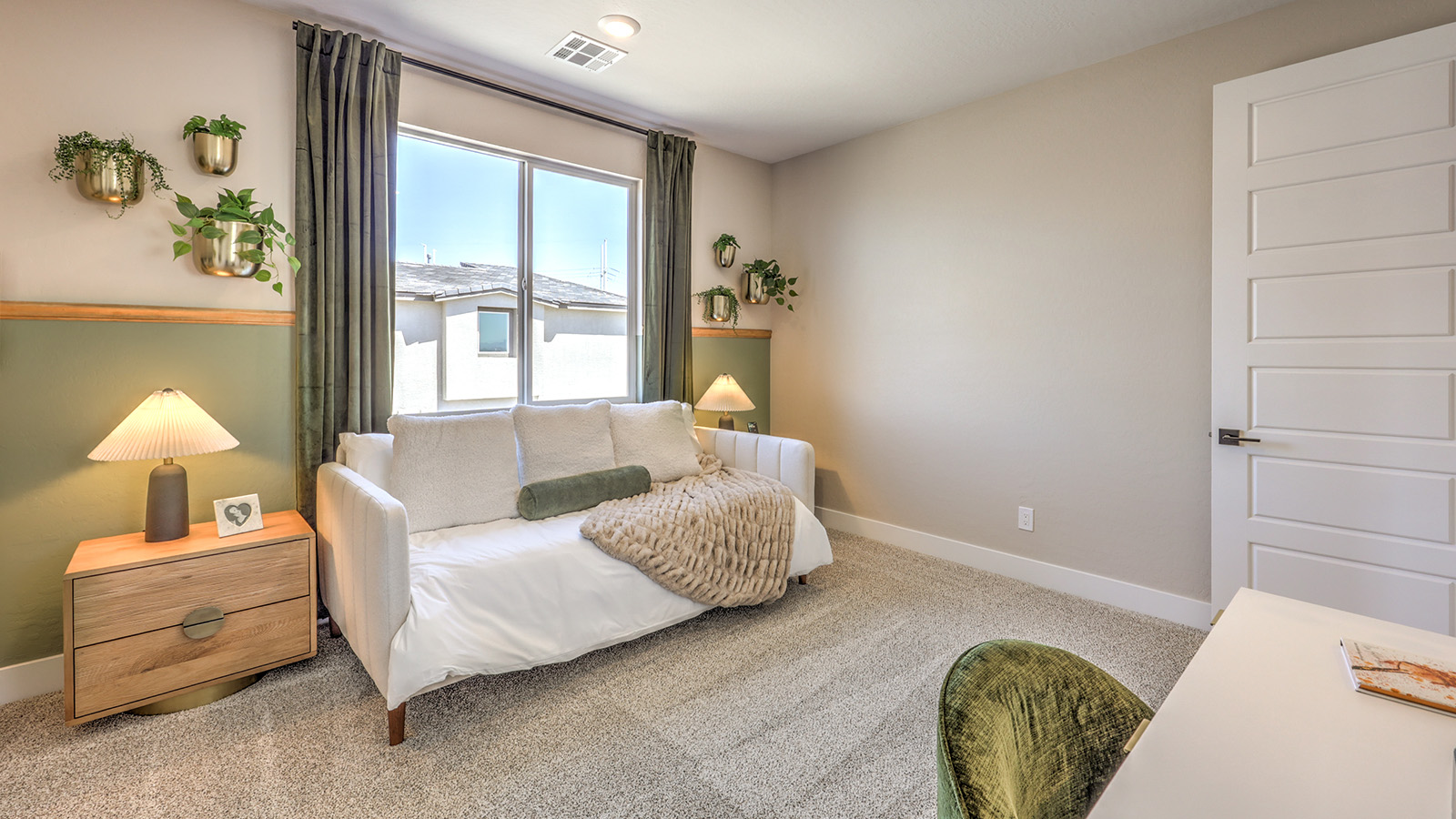 Bedroom Five in our Heartland Summit 4418 model with carpet flooring, a walk-in closet, and a window.