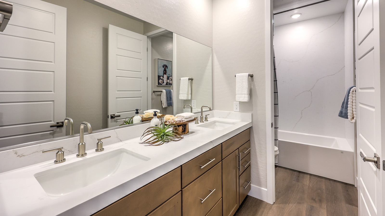 Bathroom Two in our Heartland Summit 3765 model with granite countertops at the double Bath Vanity, a walk-in shower, mirror, and white cabinets.