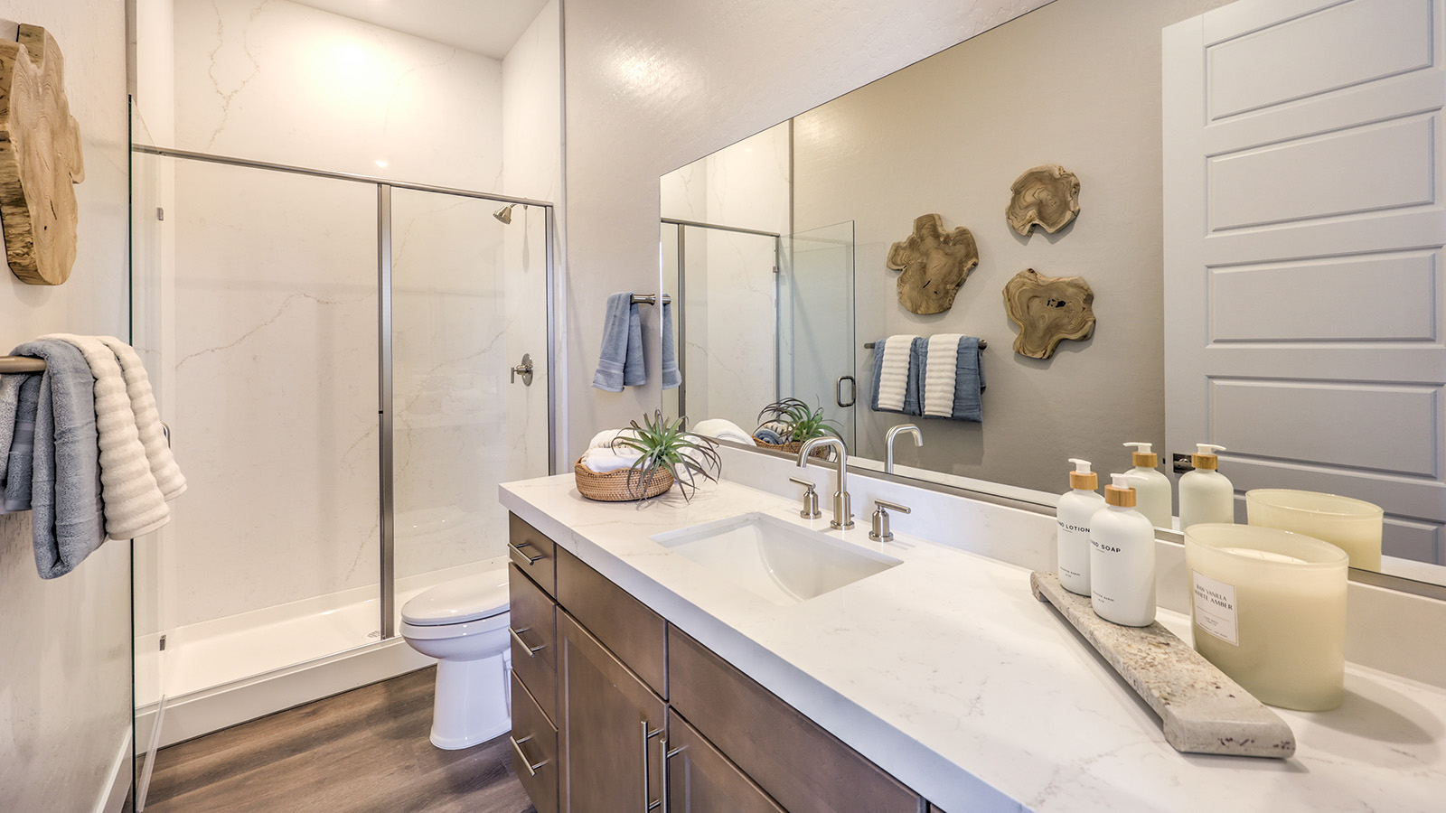 Bathroom Three in our Heartland Summit 3765 Multigen Suite with granite countertops at the Bath Vanity, a walk-in shower, mirror, and white cabinets.