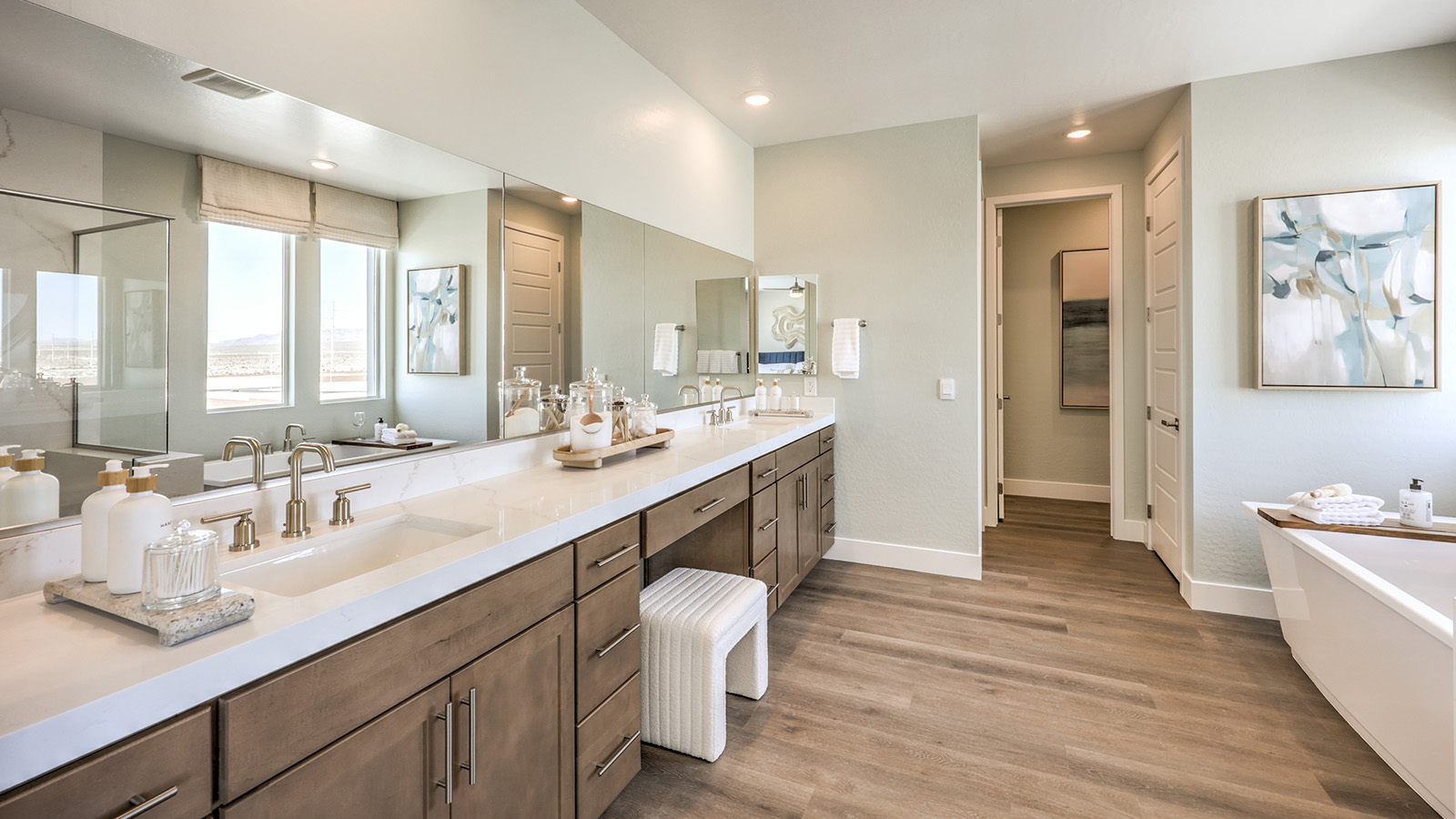 Attached to the Bedroom One Suite, our 3765 model bathroom with granite countertops at both Bath Vanities, a walk-in closet, mirror, and white cabinets.