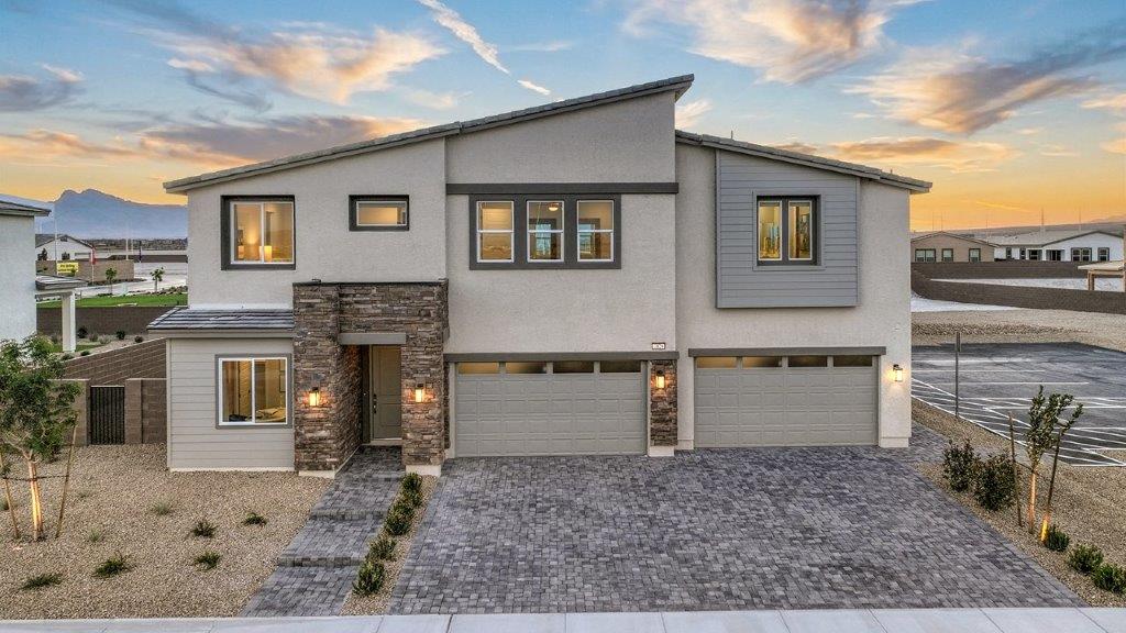 Our 3765 model home in the Heartland Summit community with tan and brown exterior paint schemes, a flat tile roof, front yard landscaping, paver walkways, and a three-car garage.