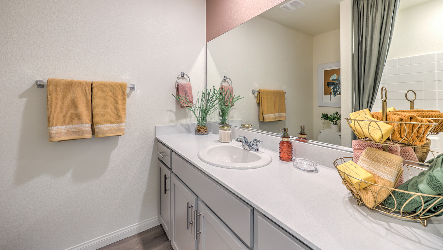 Bathroom Two in our Heartland Bay 1865 model with granite countertops at the Bath Vanity, a walk-in shower, mirror, and grey cabinets.