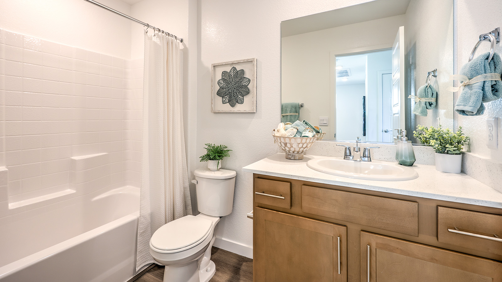 Bathroom Two in our Heartland Bay 1802 model with granite countertops at the Bath Vanity, a walk-in shower, mirror, and brown cabinets.