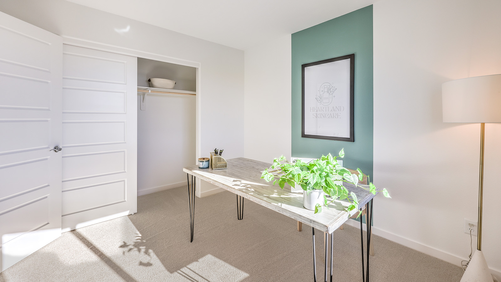 The Office/Bedroom Four option in our Heartland Bay 1802 model with carpet flooring, a sliding closet, and a window, furnished with a desk and chair.