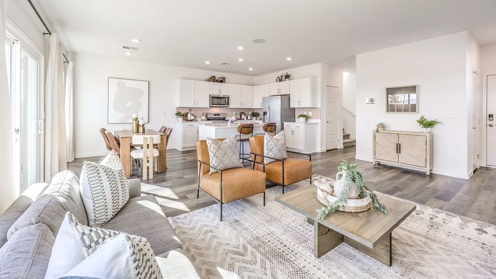 The Heartland Bay 1872 Plan open concept Great Room with LVP panel flooring, two large windows, and a sliding door to the backyard.