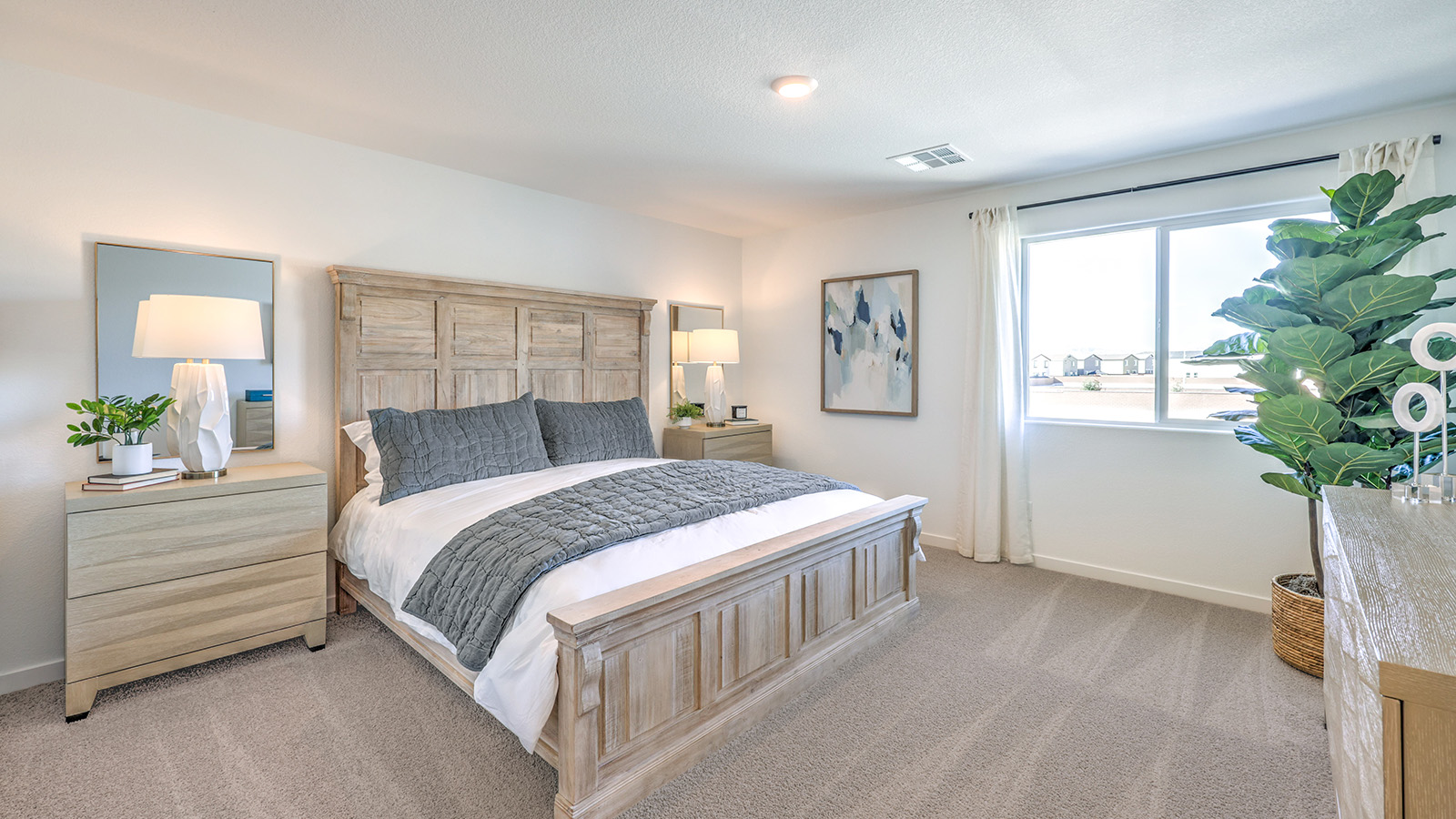 The Bedroom One Suite in our Heartland Bay 1872 model with carpet flooring, walk-in closet, and a ceiling fan with a light kit.
