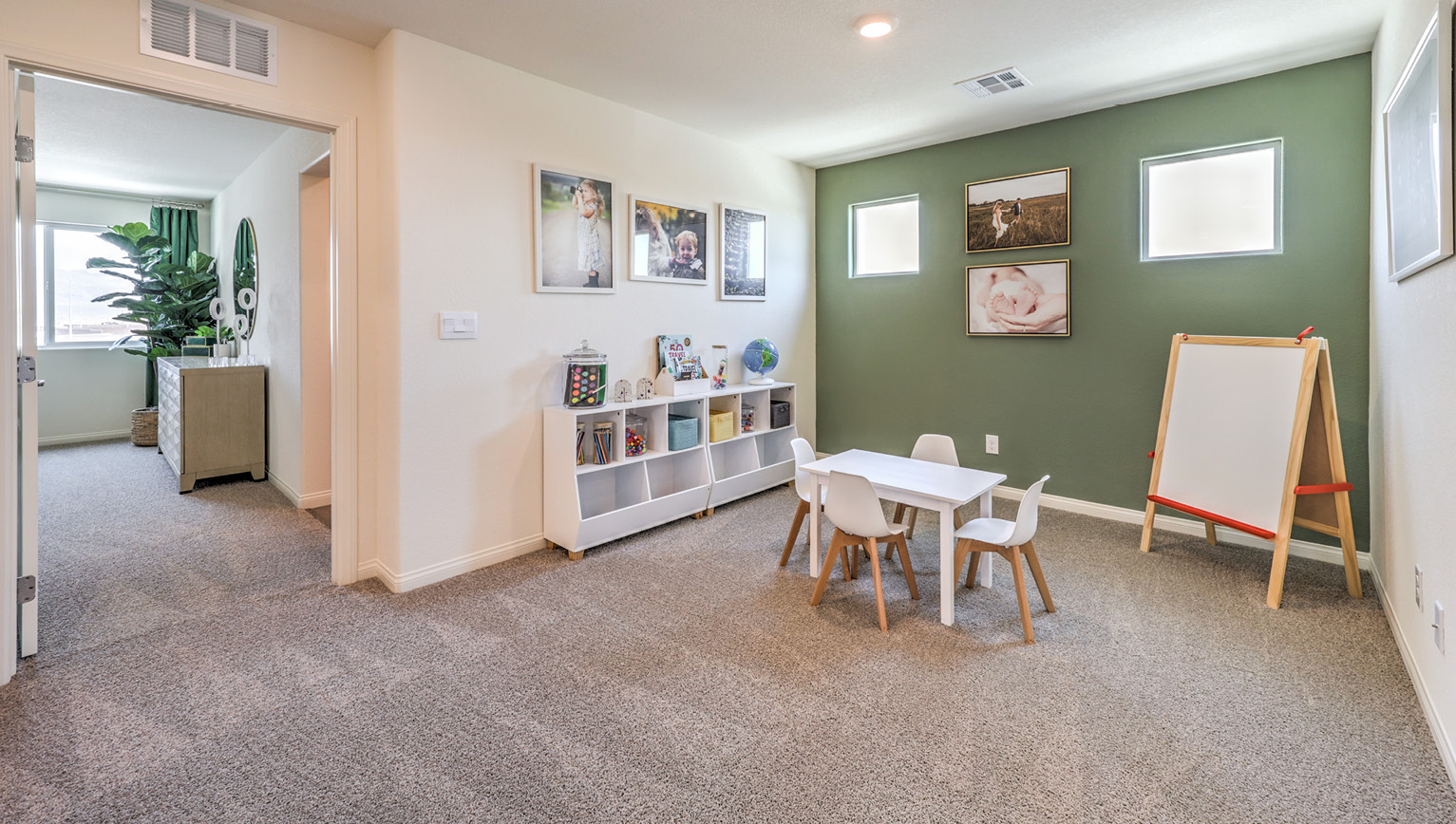 The loft in our Heartland Bay 1865 plan with carpet flooring and two windows