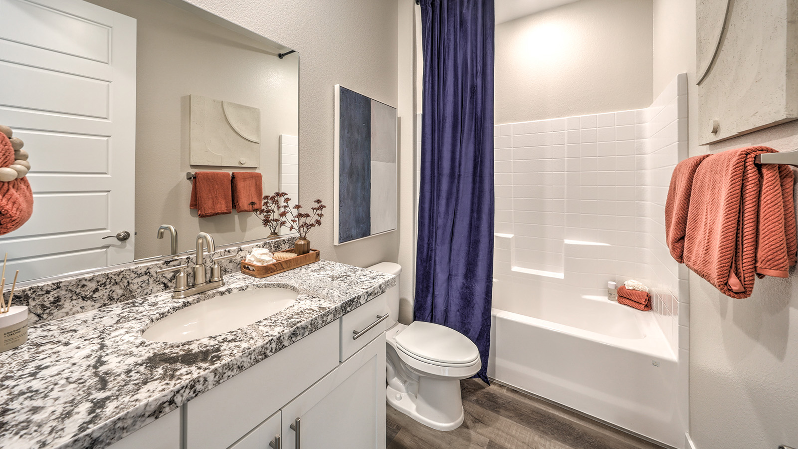 Bathroom Two in our Heartland Grove 1839 model with quartz/marble fusion countertops at the Bath Vanity, a walk-in shower, mirror, and white cabinets.