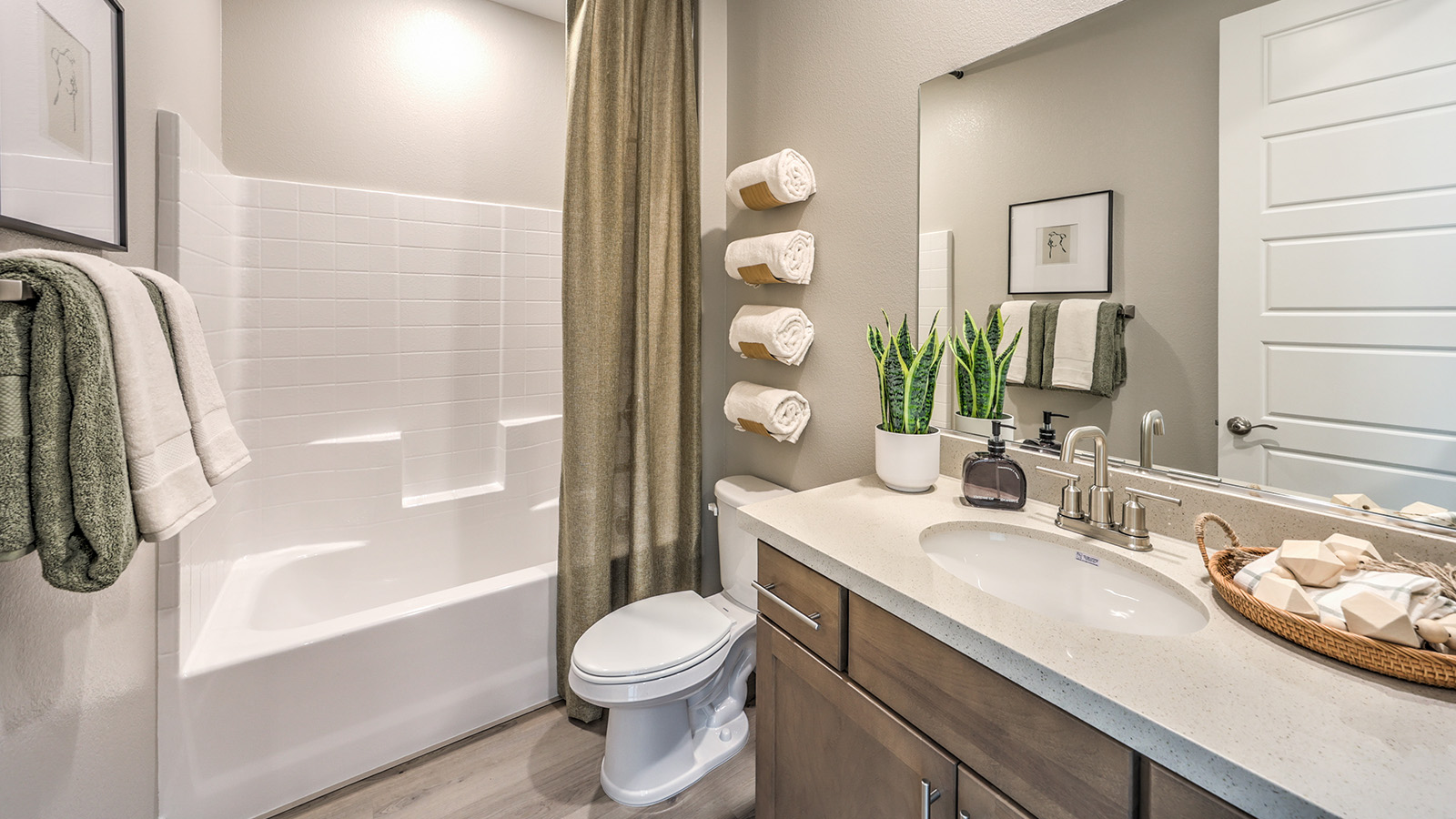 Bathroom Two in our Heartland Grove 2048 model with quartz/marble fusion countertops at the Bath Vanity, a walk-in shower, mirror, and white cabinets.