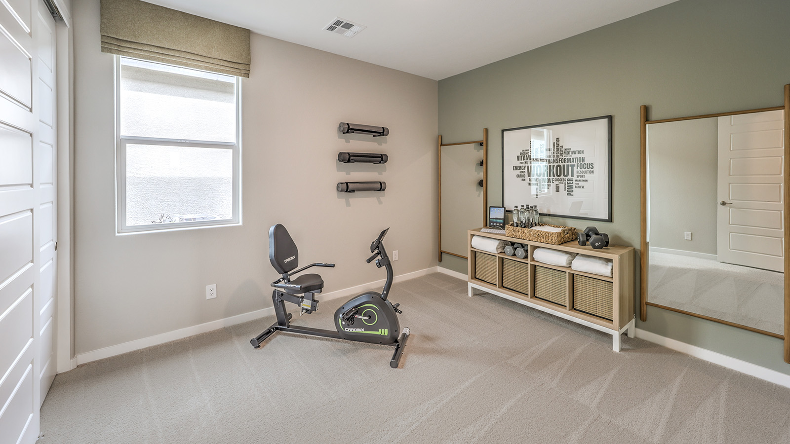 The Office/Bedroom Two option in our Heartland Grove 2048 model with carpet flooring and a window, furnished with a desk and chair.