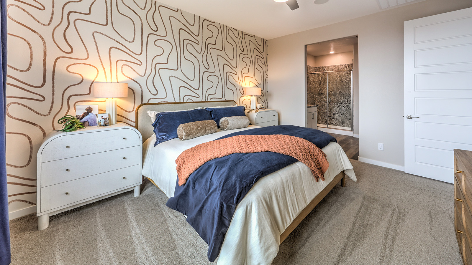 The Bedroom One Suite in our Heartland Grove 1839 model with carpet flooring, large windows, and recessed ceiling lights.