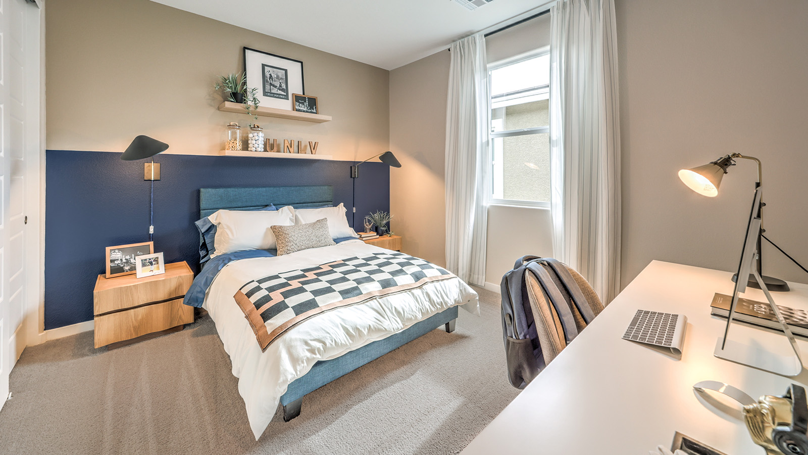 The Office/Bedroom Two option in our Heartland Grove 1839 model with carpet flooring and a window, furnished with a desk and chair.