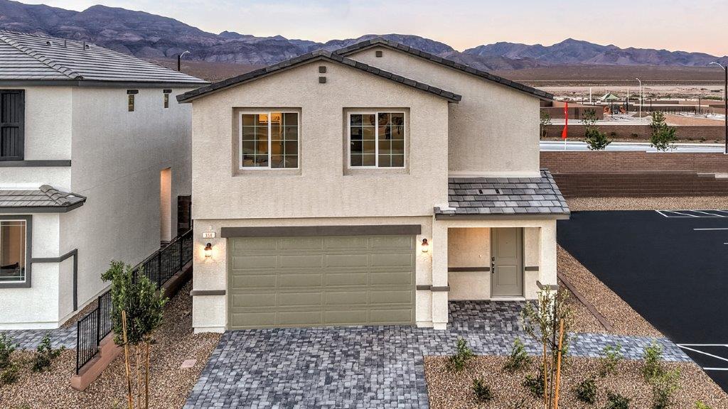 Our 1700 model home in the Heartland Cottages community with white and tan exterior paint schemes, a flat tile roof, front yard landscaping, and paver walkways.