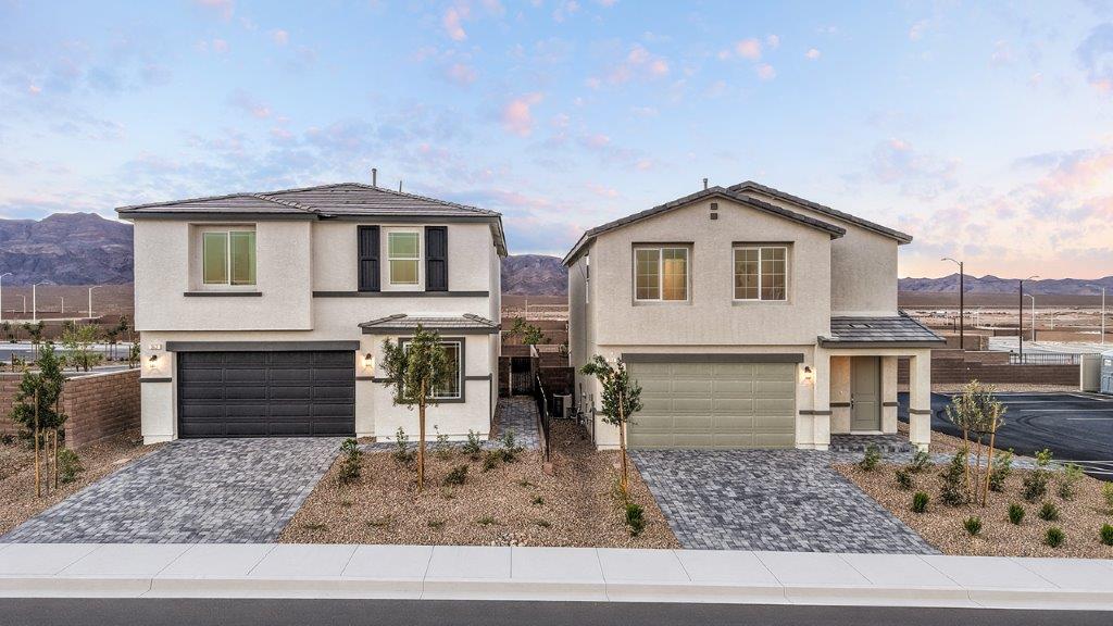 Our 1865 model home in the Heartland Cottages community with white and black exterior paint schemes, a flat tile roof, front yard landscaping, and paver walkways.